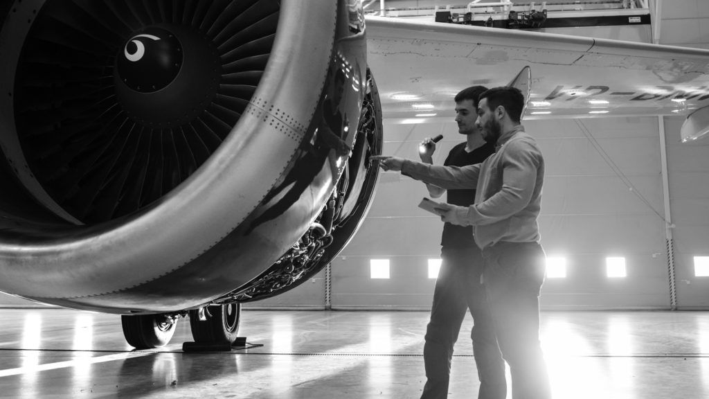 men looking at airplane