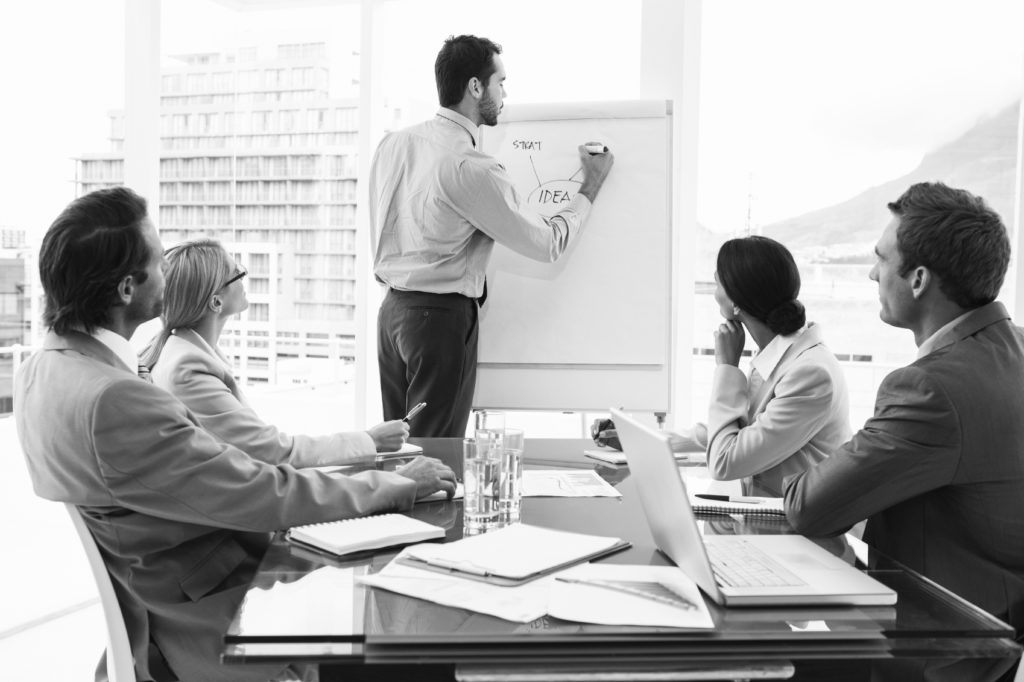 PHOTO business man giving presentation to group in conference room BW consultant making presentation
