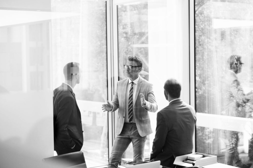 Businessman Discussing With Colleagues At Office people talking in office
