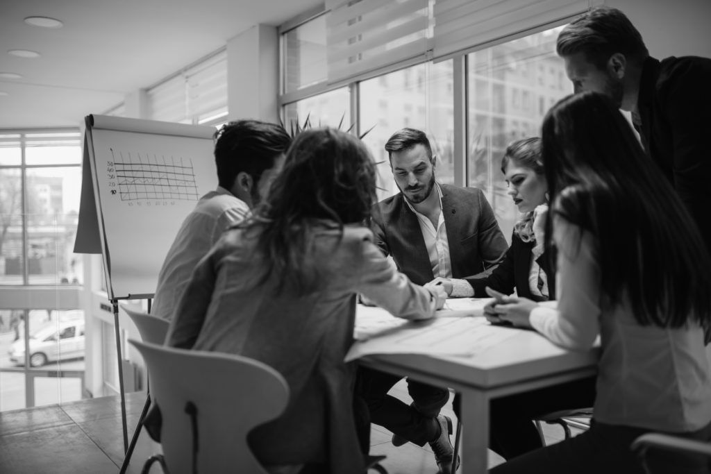 shutterstock_595897442 people talking at desk in office