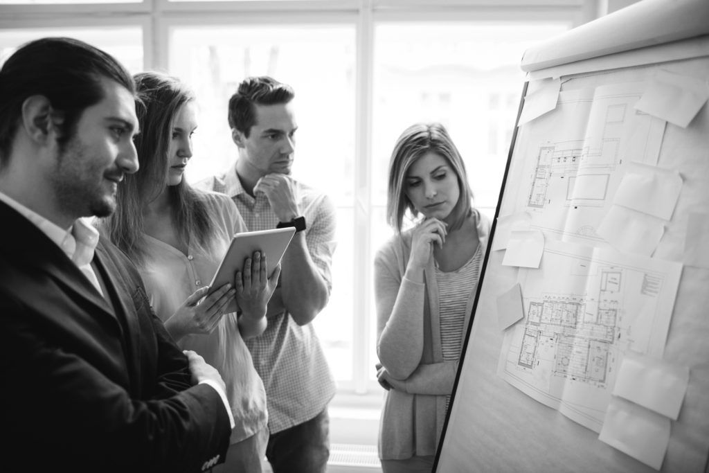 shutterstock_448922863 consultants working in office looking in flipchart