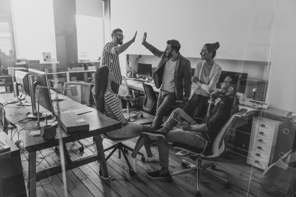 shutterstock_583521010 men high fiving in office