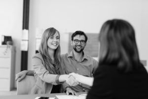 consultants in group working at desk shaking hands
