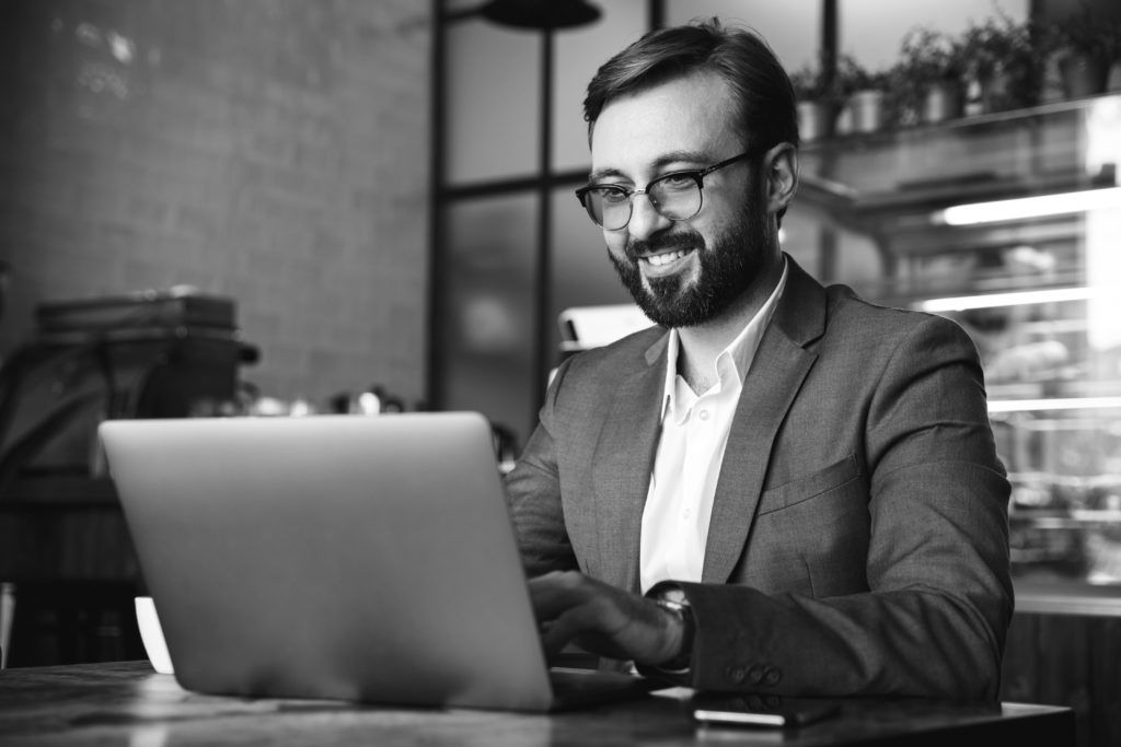 happy consultant working on laptop in restaurant