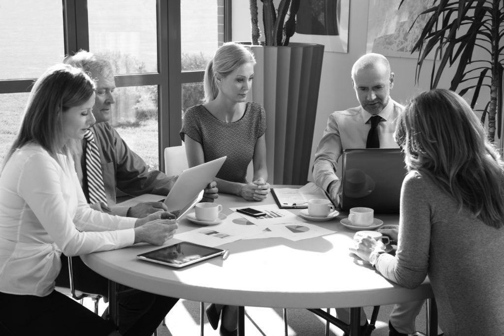 shutterstock_287678567 consultants in group working at desk