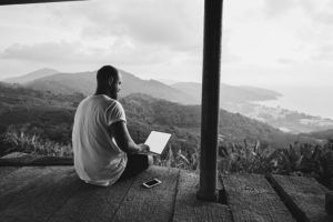 man working at computer looking at mountain