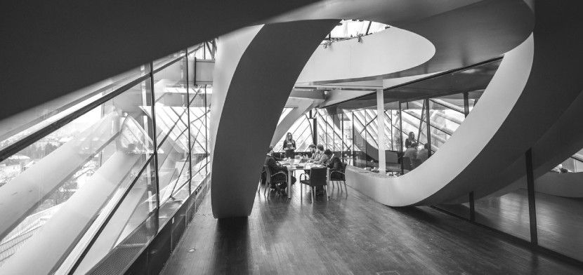 people talking at table with winding staircase img