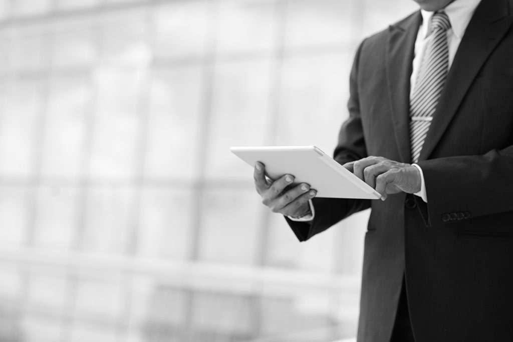 shutterstock_326814341 man standing working on tablet