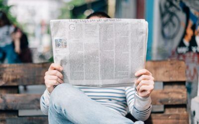 man-sitting-on-bench-reading-newspaper